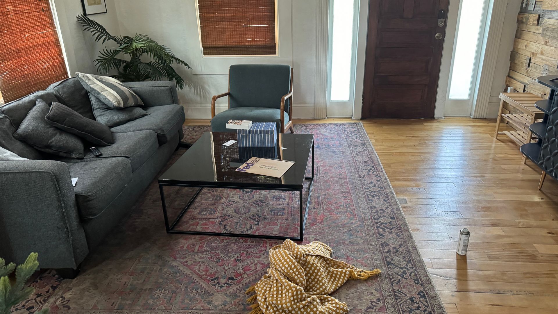 A living room with a couch , chair , coffee table and rug.