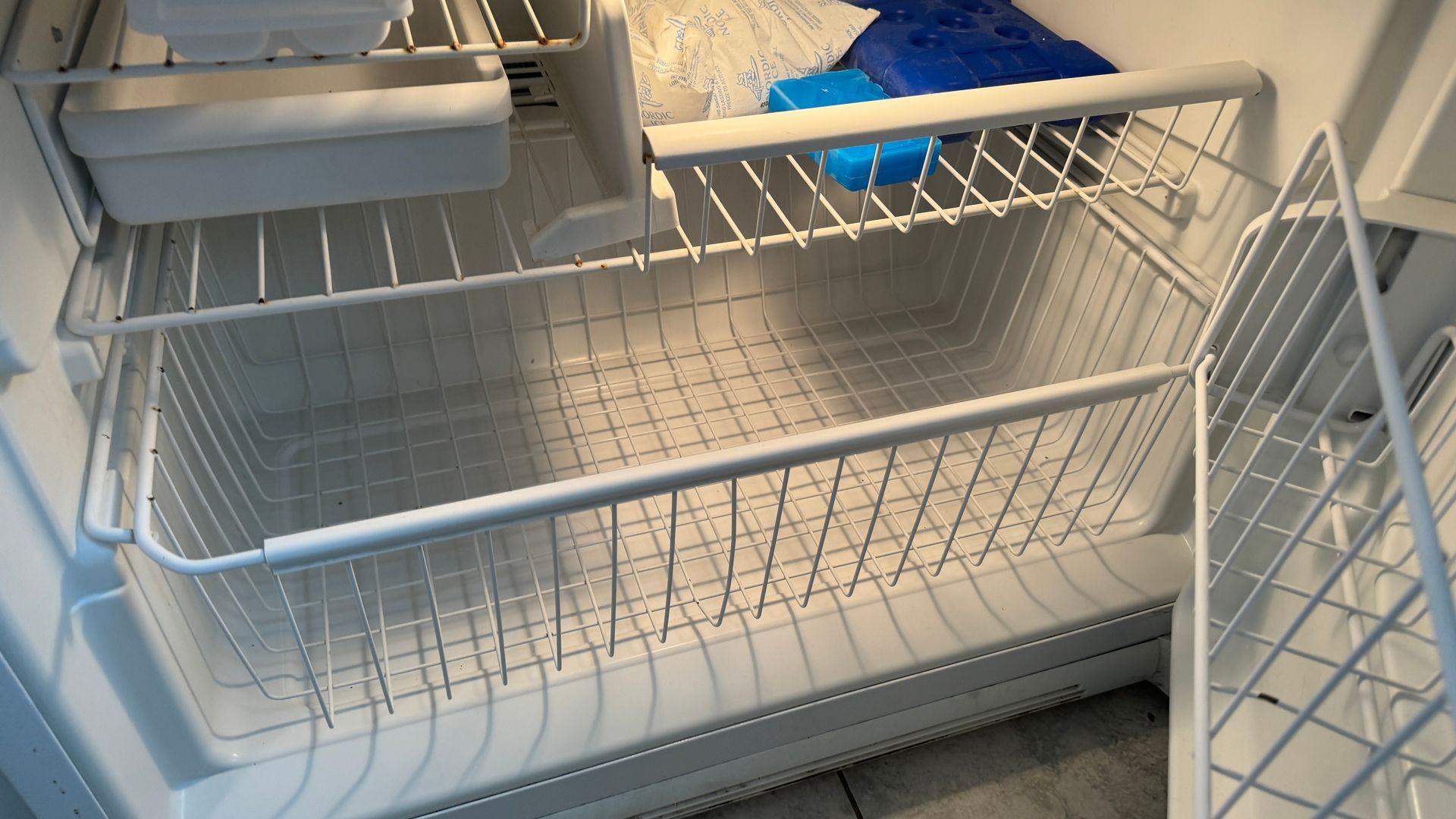 The inside of an empty refrigerator with the door open