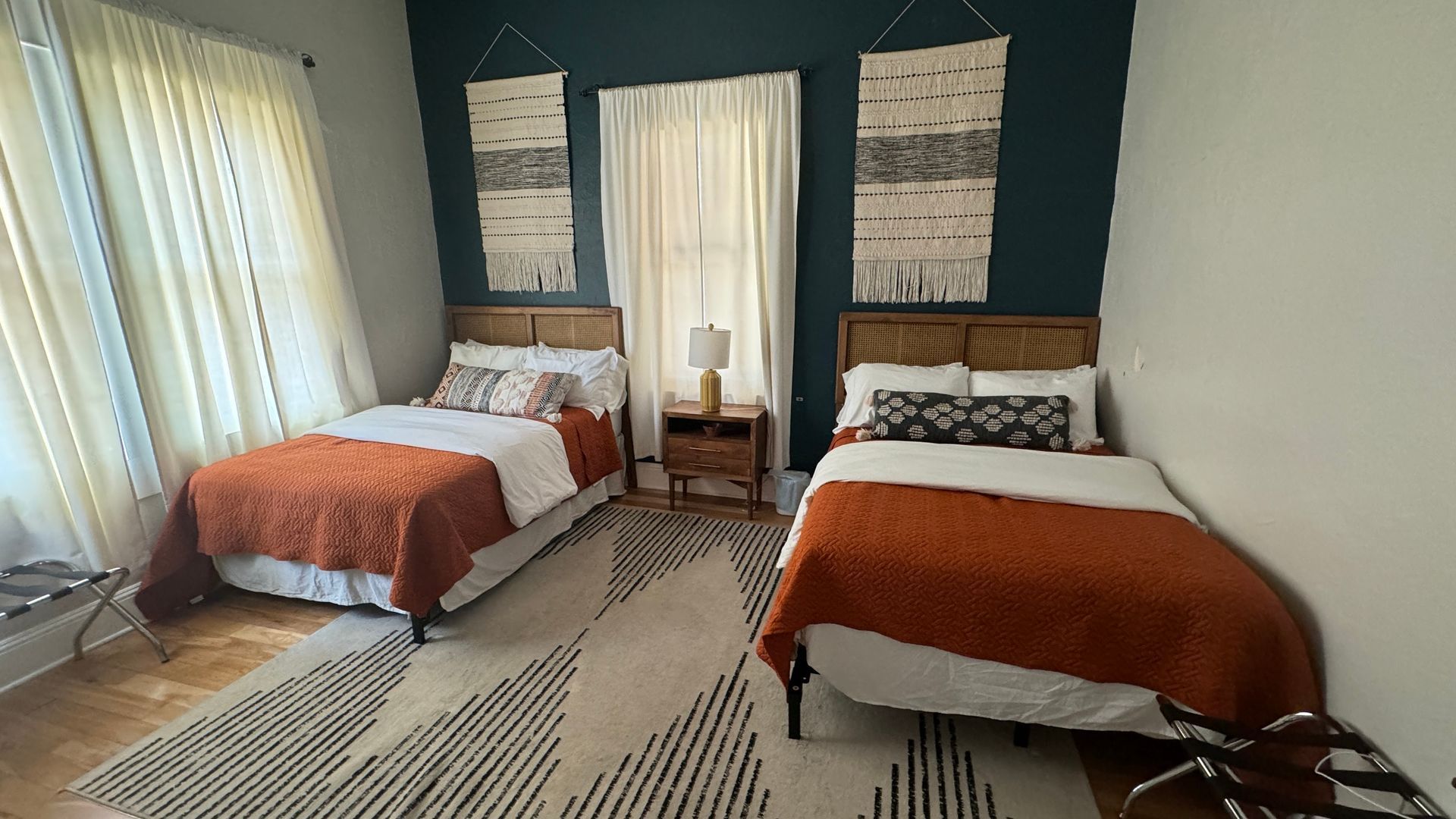 A bedroom with two beds and a rug.