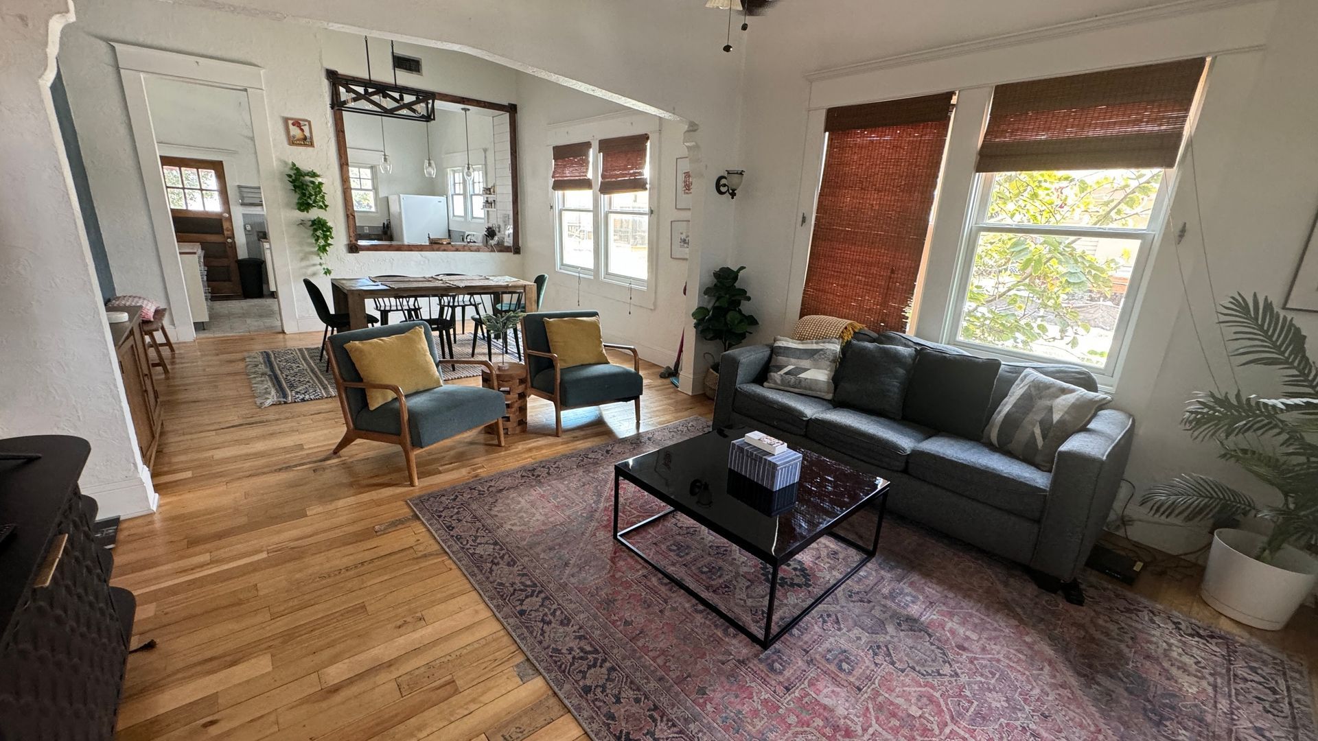 A living room with a couch , chairs , and a coffee table.