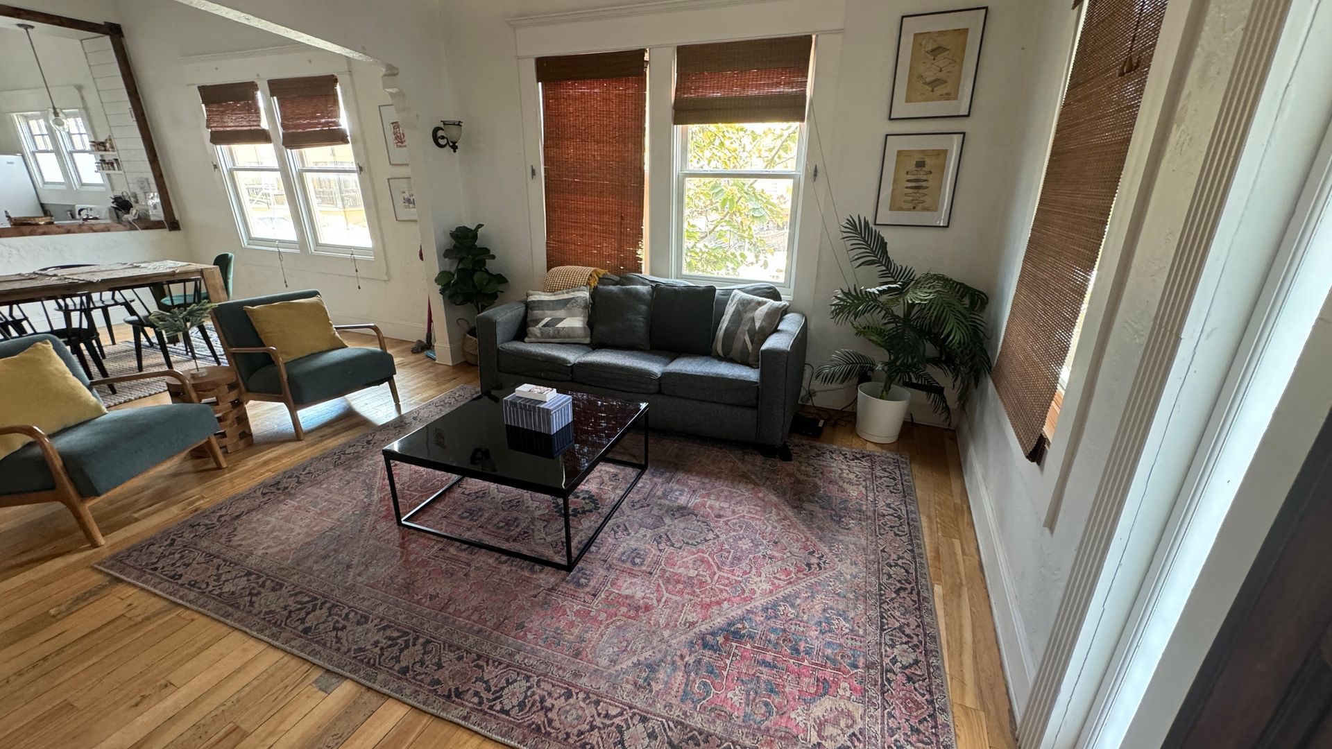 A living room with a couch , chairs , coffee table and rug.