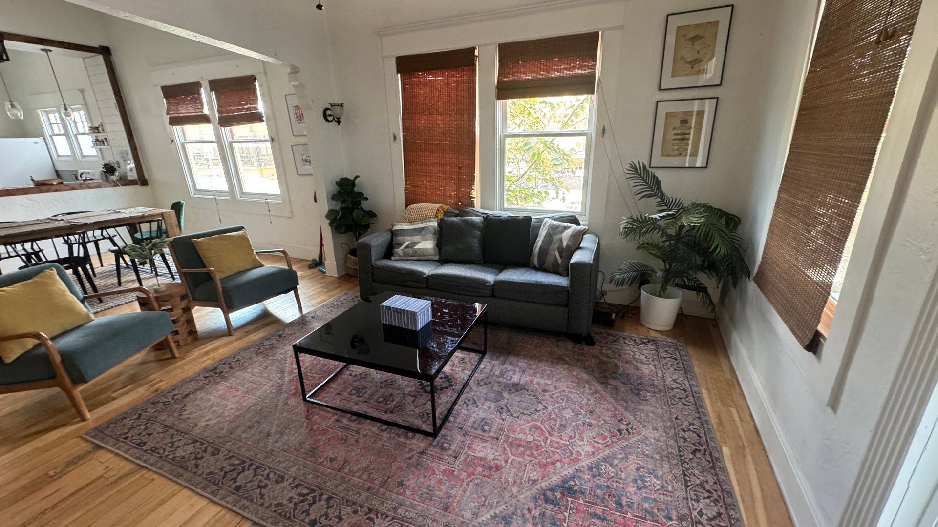 A living room with a couch , chairs , coffee table and rug.