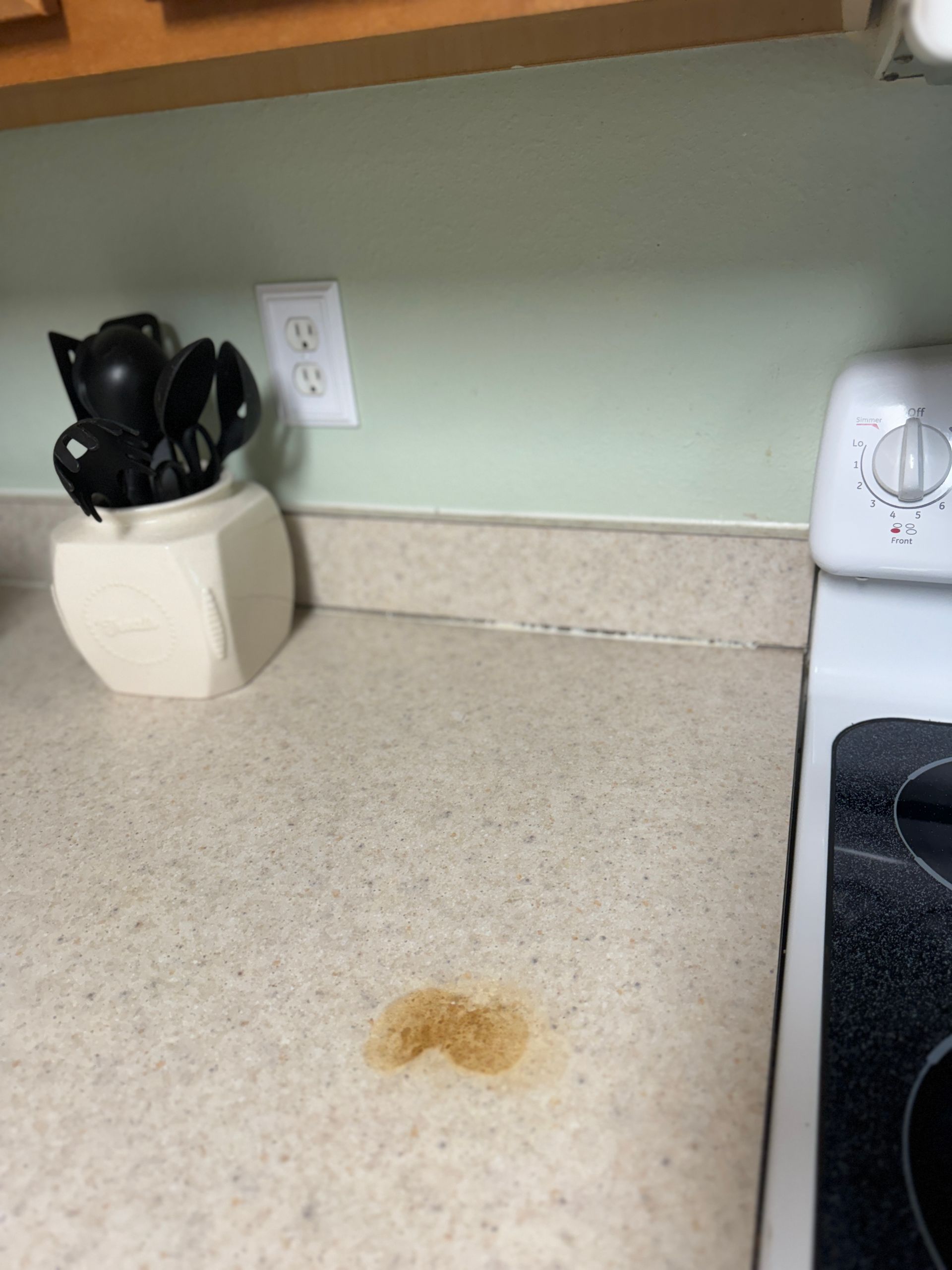 A kitchen counter with a pot of utensils on it