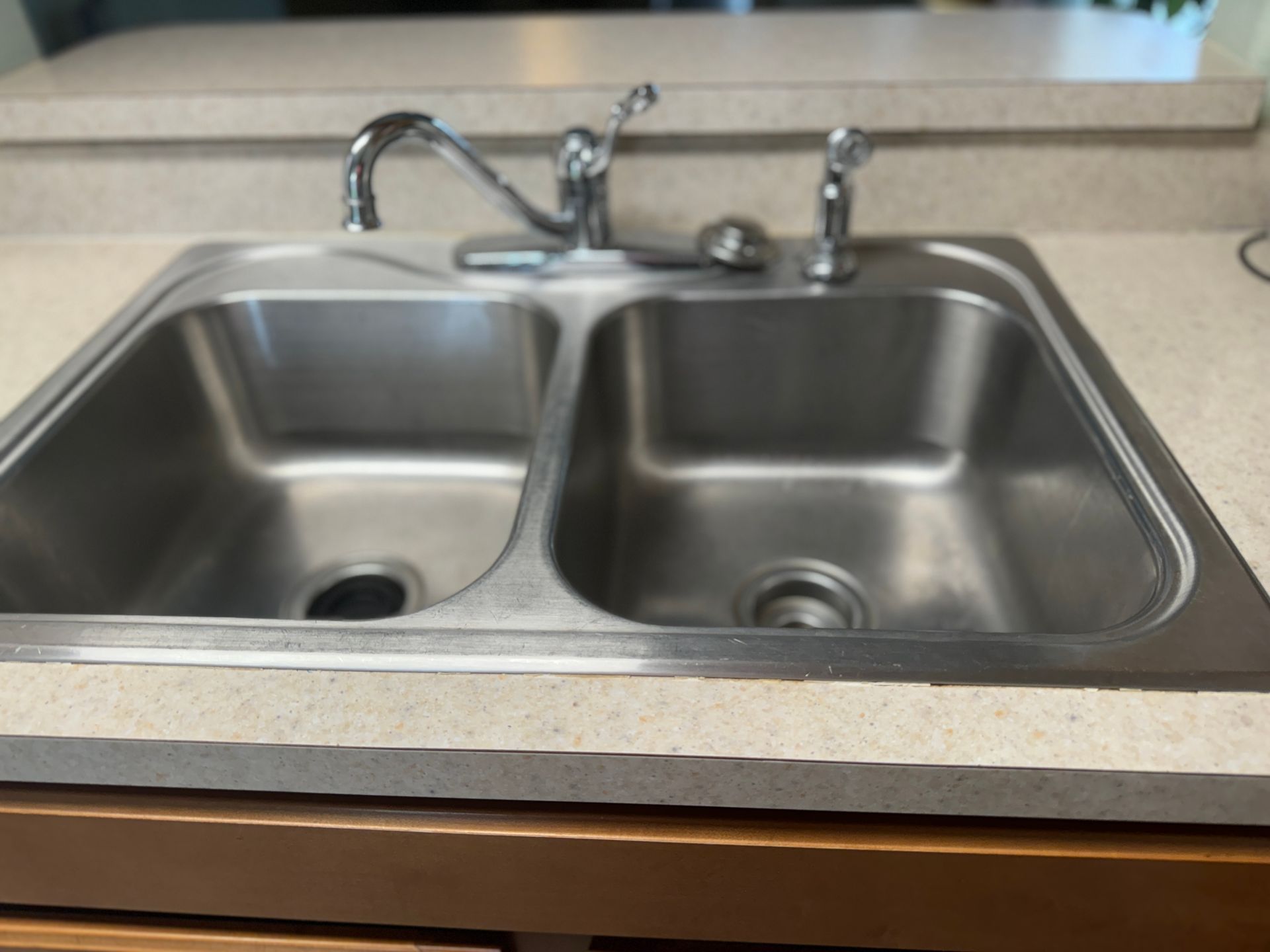 A stainless steel kitchen sink with a faucet