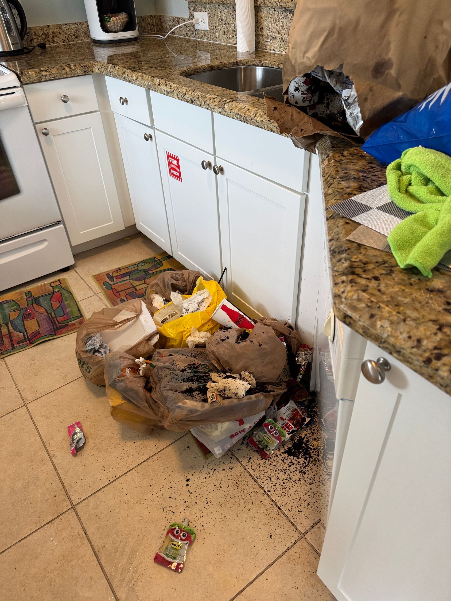 A kitchen with a lot of trash on the floor