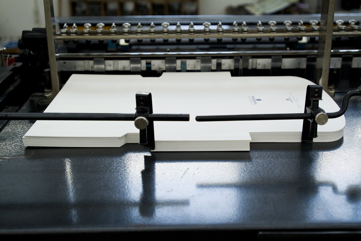un macchinario da stampa e sotto dei fogli stampati Grafiche-venete-padova-015 - un macchinario da stampa