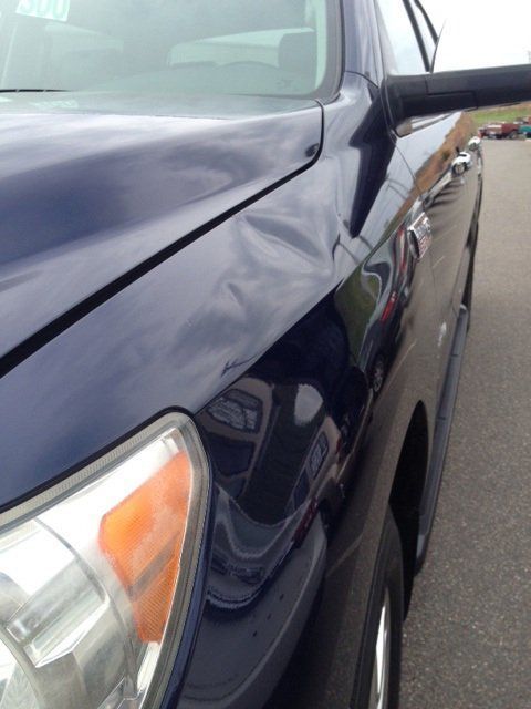 A blue car is parked on the side of the road