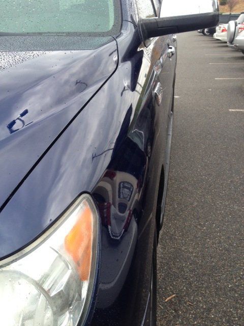 A blue car is parked in a parking lot
