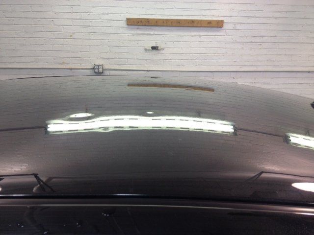 A close up of the hood of a car in a garage.