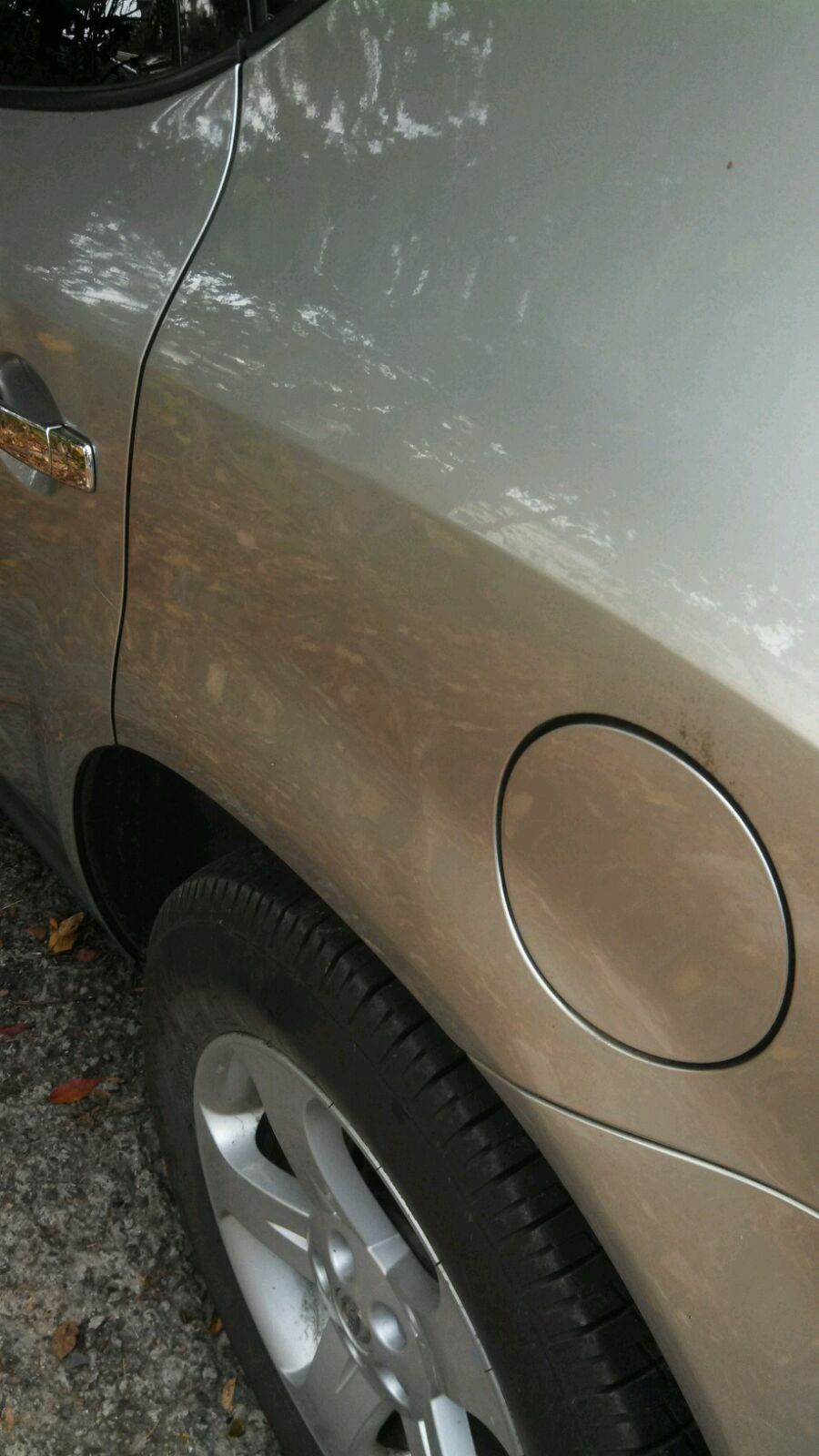 A close up of a car 's fender with a hole in it