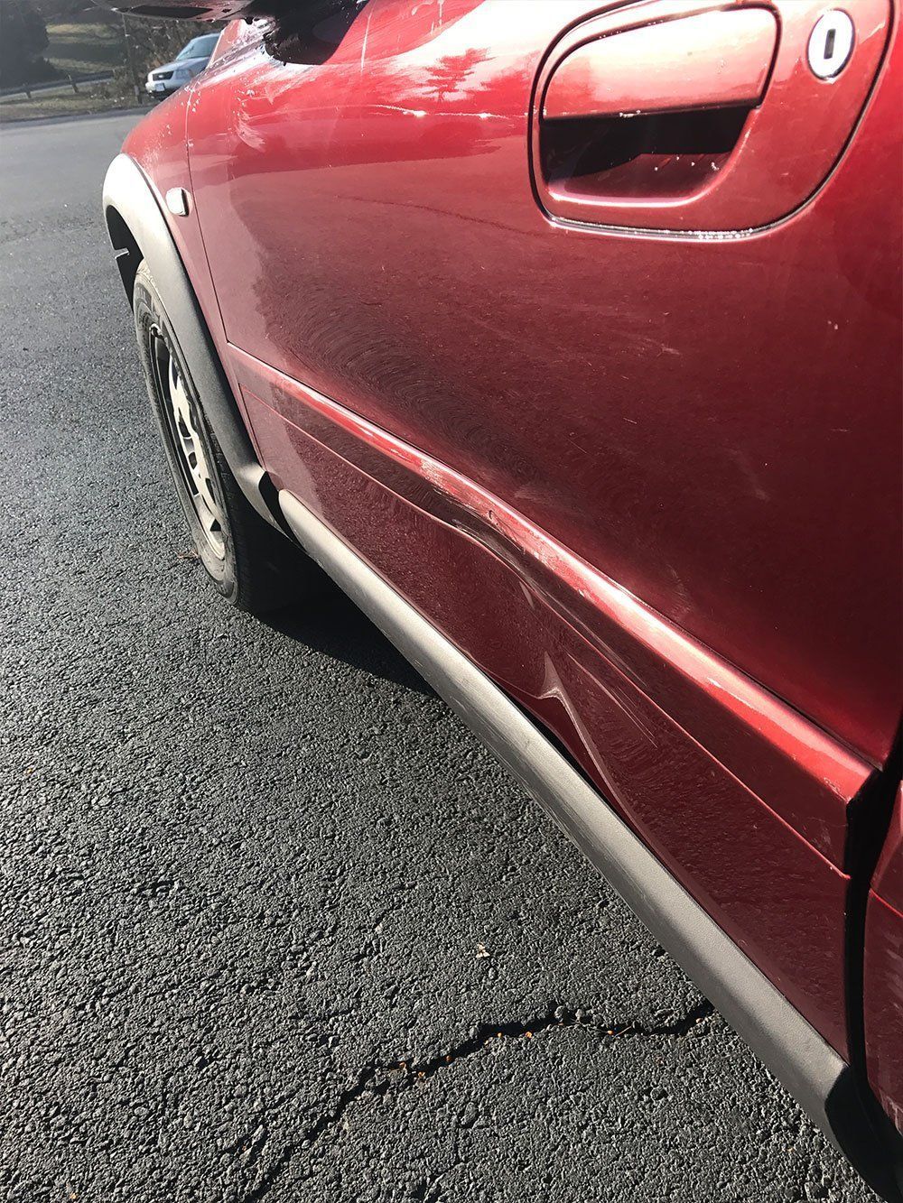 A red car is parked on the side of the road.