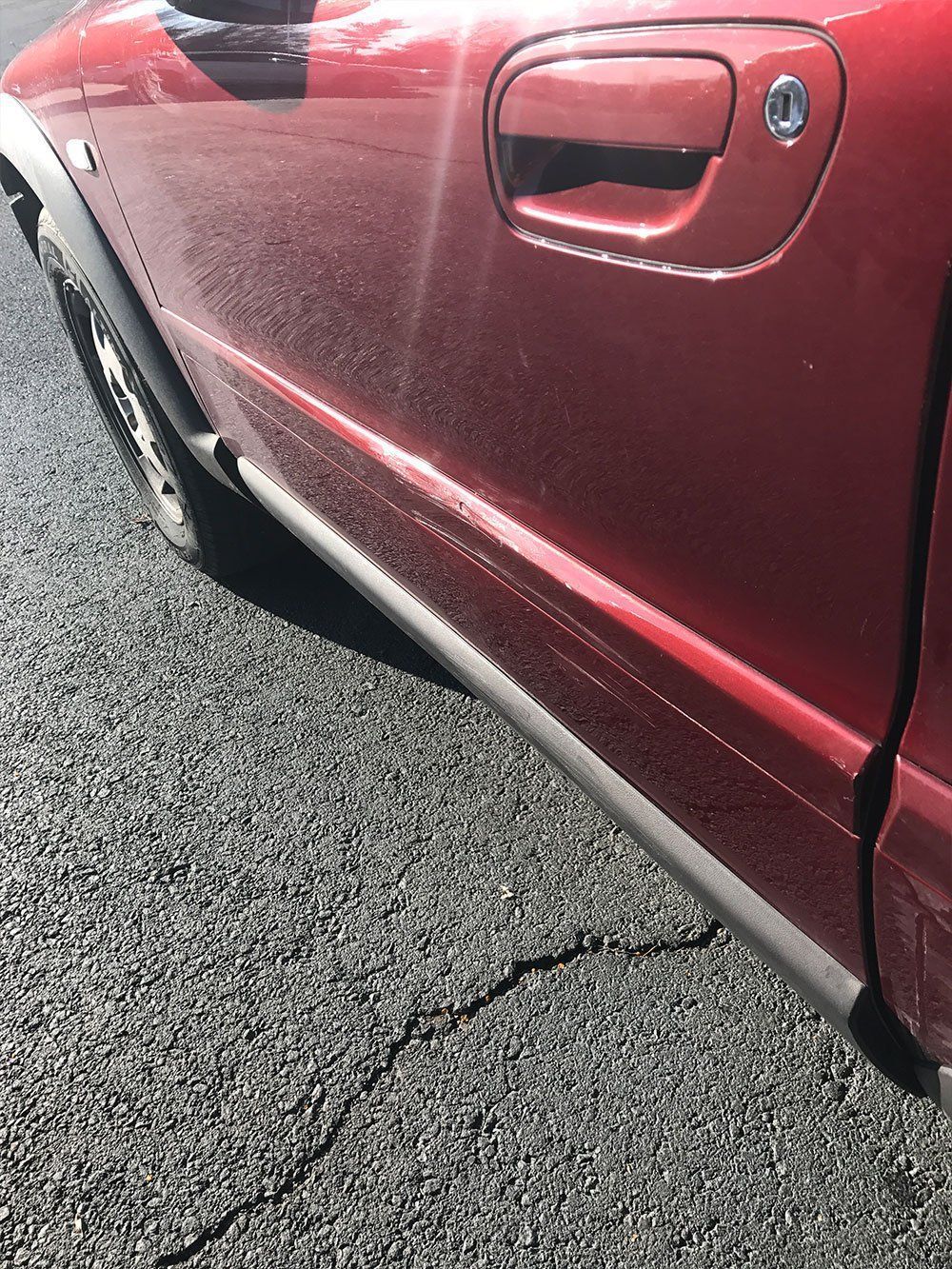 A red car is parked on the side of the road.