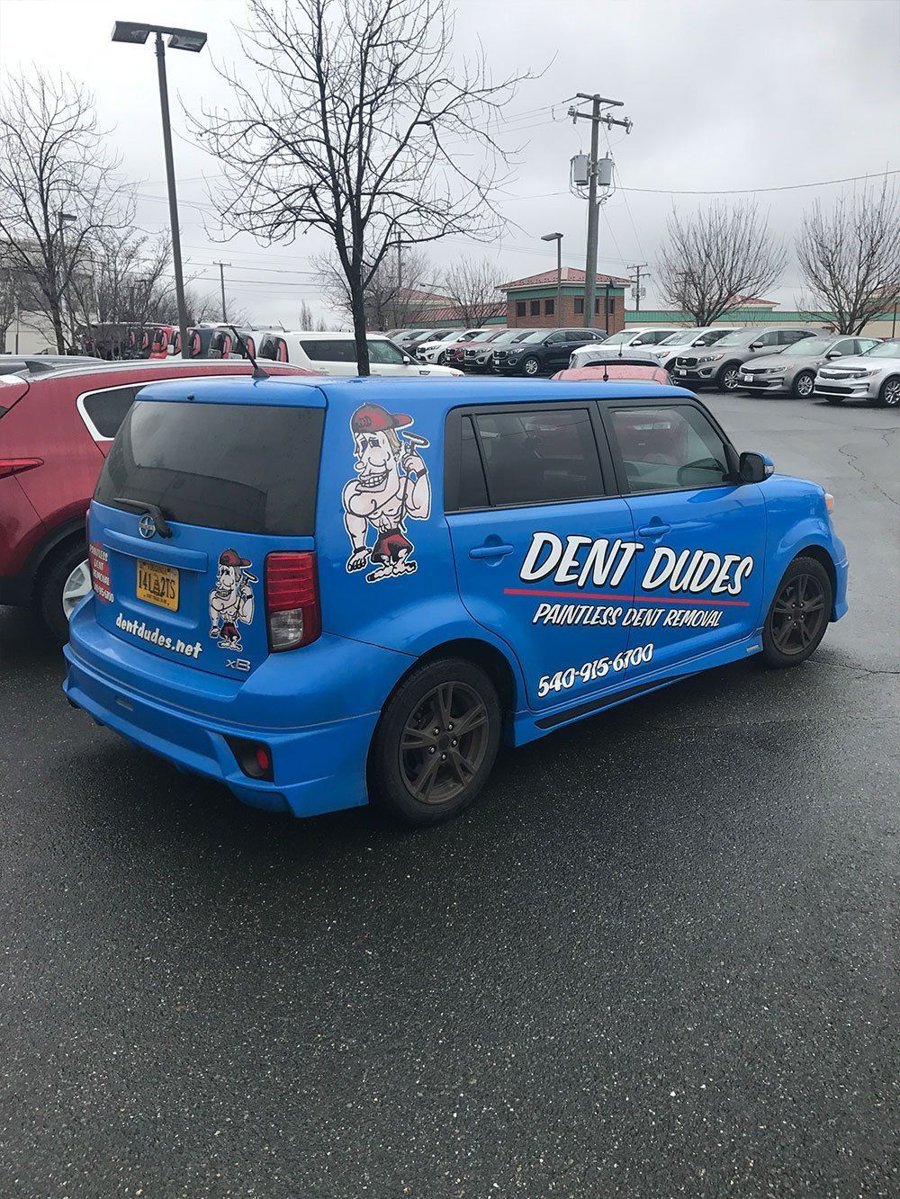 A blue minivan is parked in a parking lot.