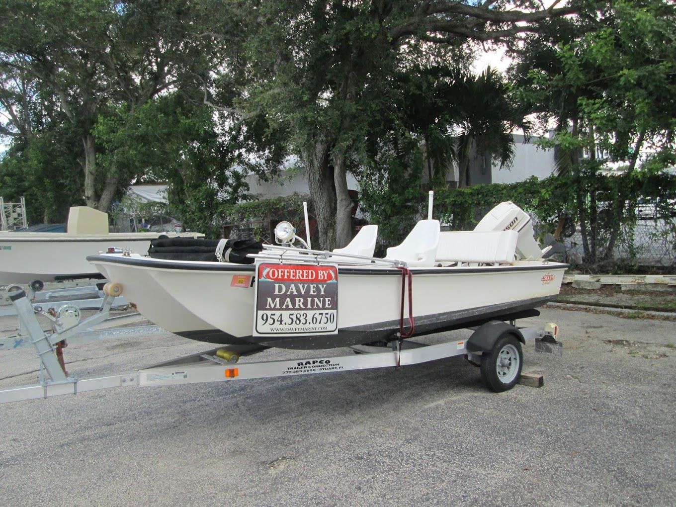 A white boat on a trailer with a sign that says davey marine