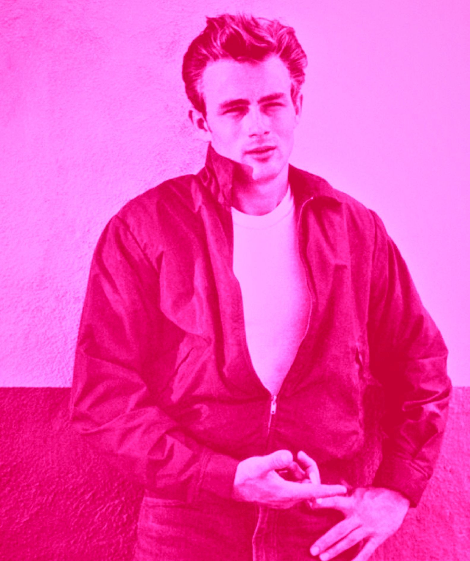 James Dean in a pink-tinted photo, wearing a jacket and white t-shirt, gesturing with his fingers.