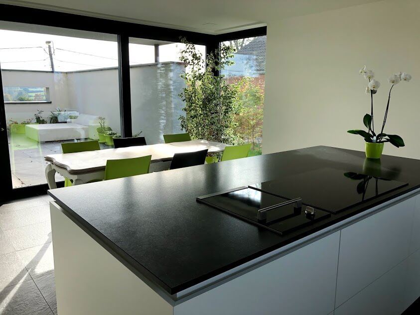 Moderne leefkeuken met kookeiland granieten werkblad - Architectengroep Janssens