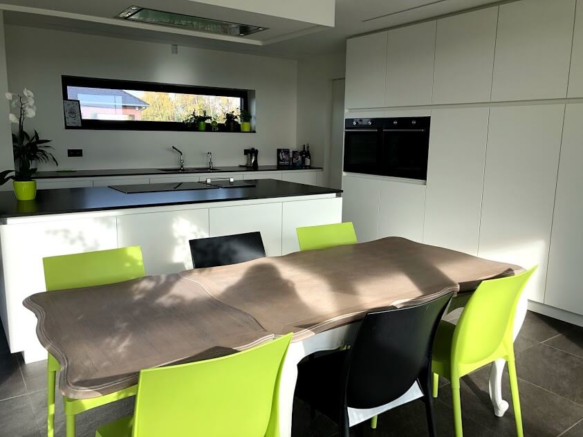 Moderne leefkeuken met kookeiland en ingebouwde ovens - Architectengroep Janssens