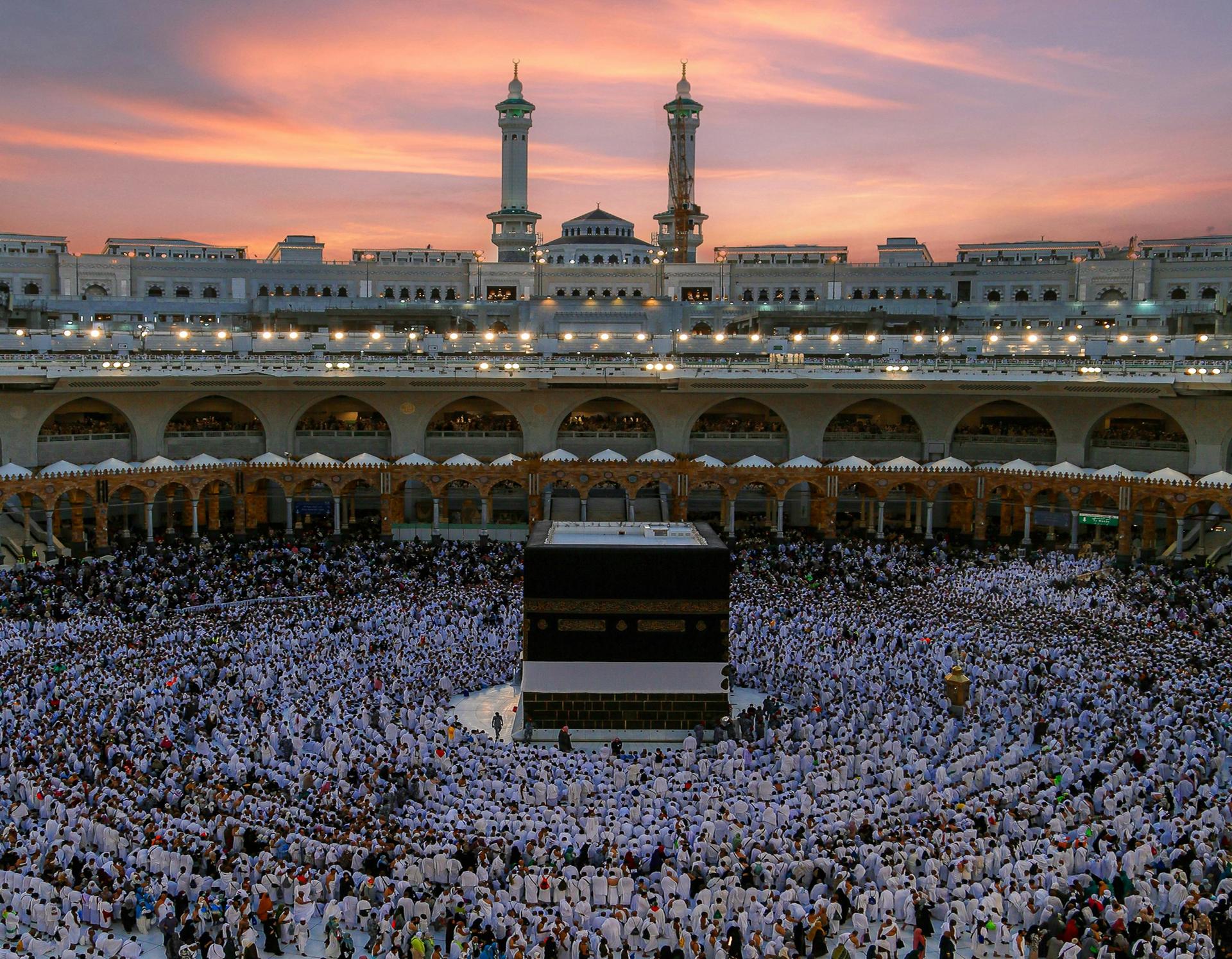 A large group of people are gathered in front of a large building.