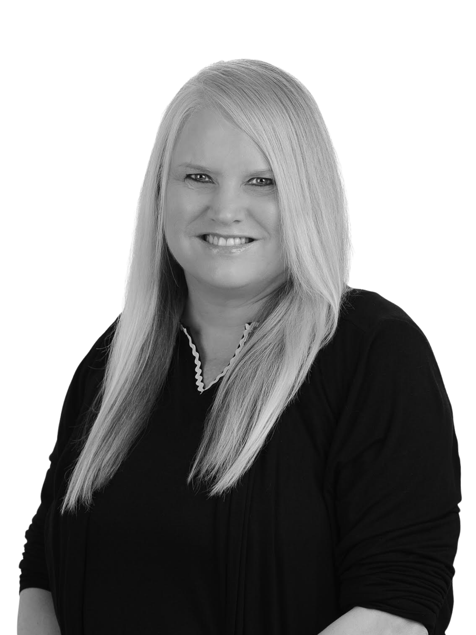 A woman with curly hair is smiling in a black and white photo.