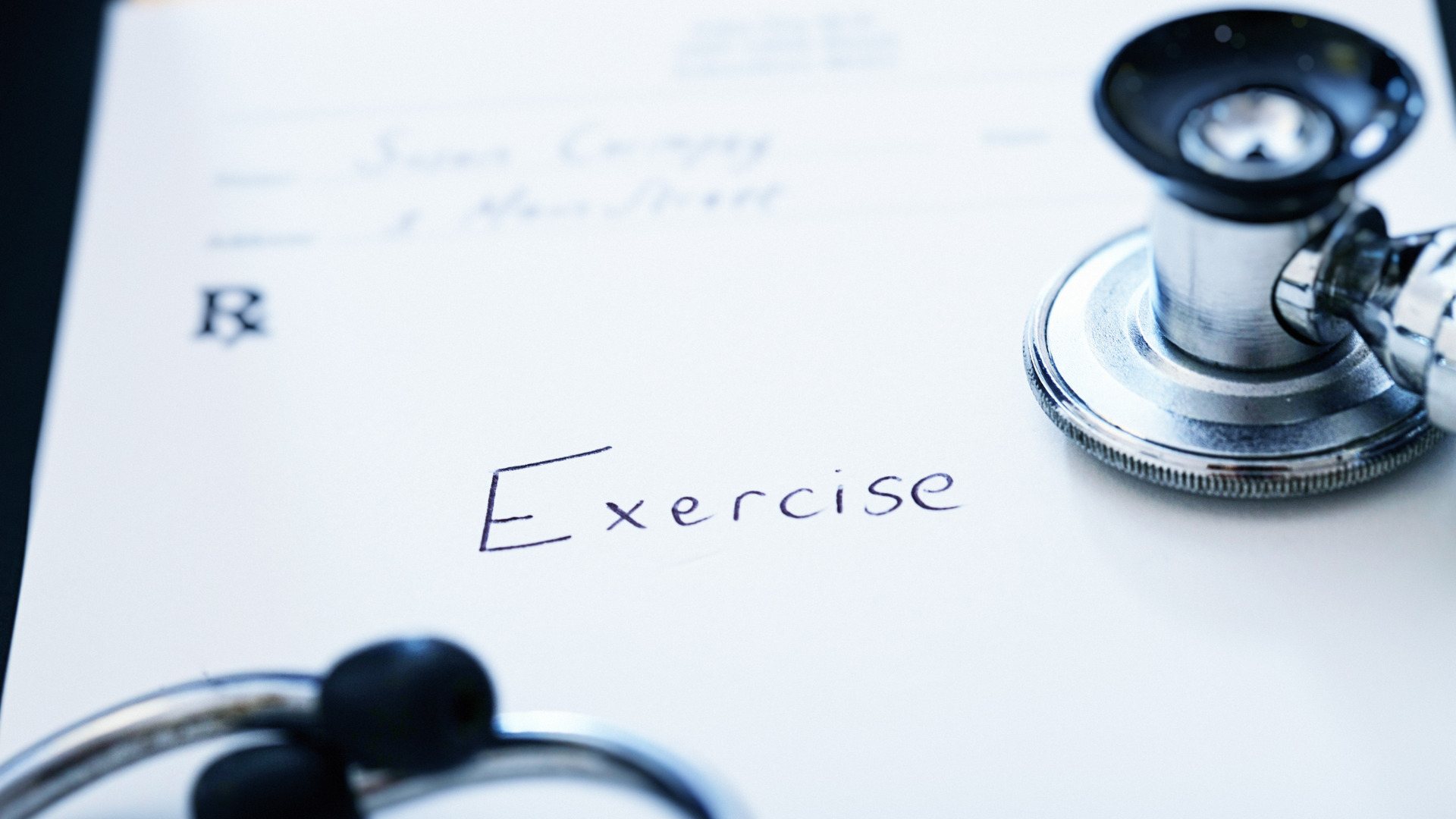 A stethoscope is sitting on top of a piece of paper that says exercise