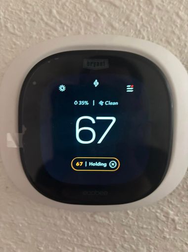 Smart thermostat displaying 67 degrees and