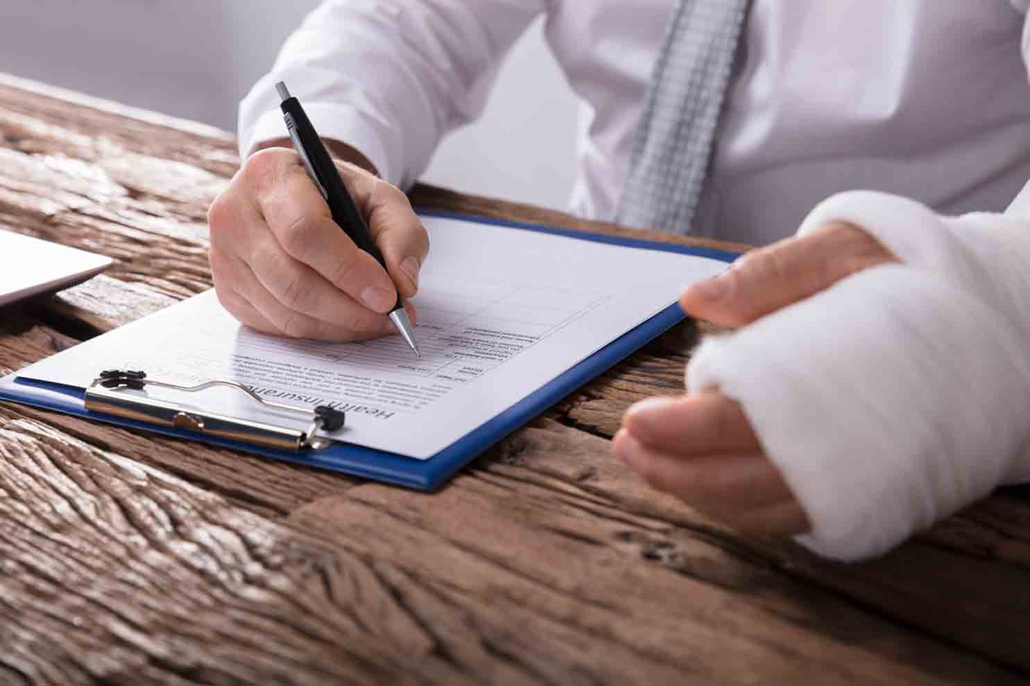 Injured Man Signing a Document — Orangeburg, SC — Dean Law Firm
