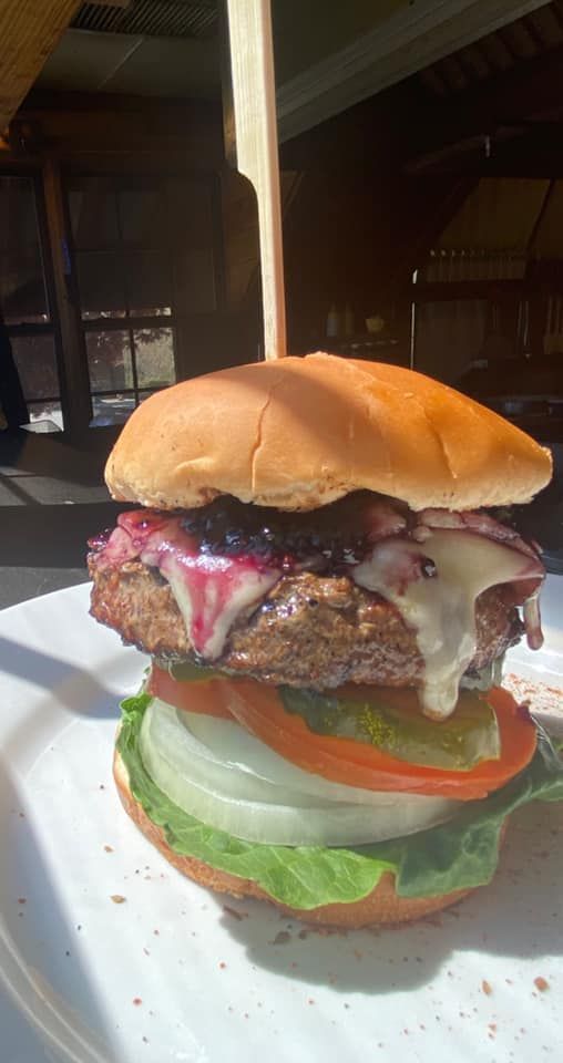 A close up of a hamburger on a white plate.