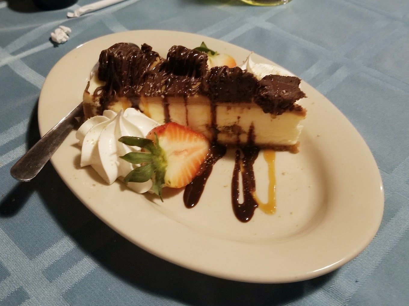 A slice of cheesecake with whipped cream and strawberries on a plate