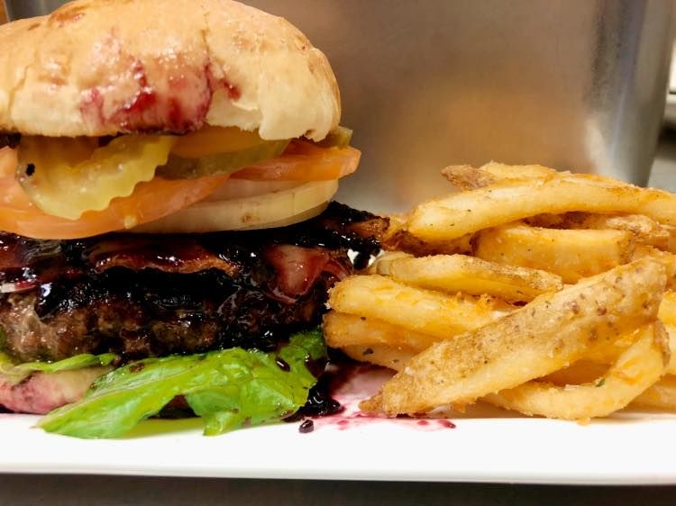 A hamburger and french fries on a white plate.