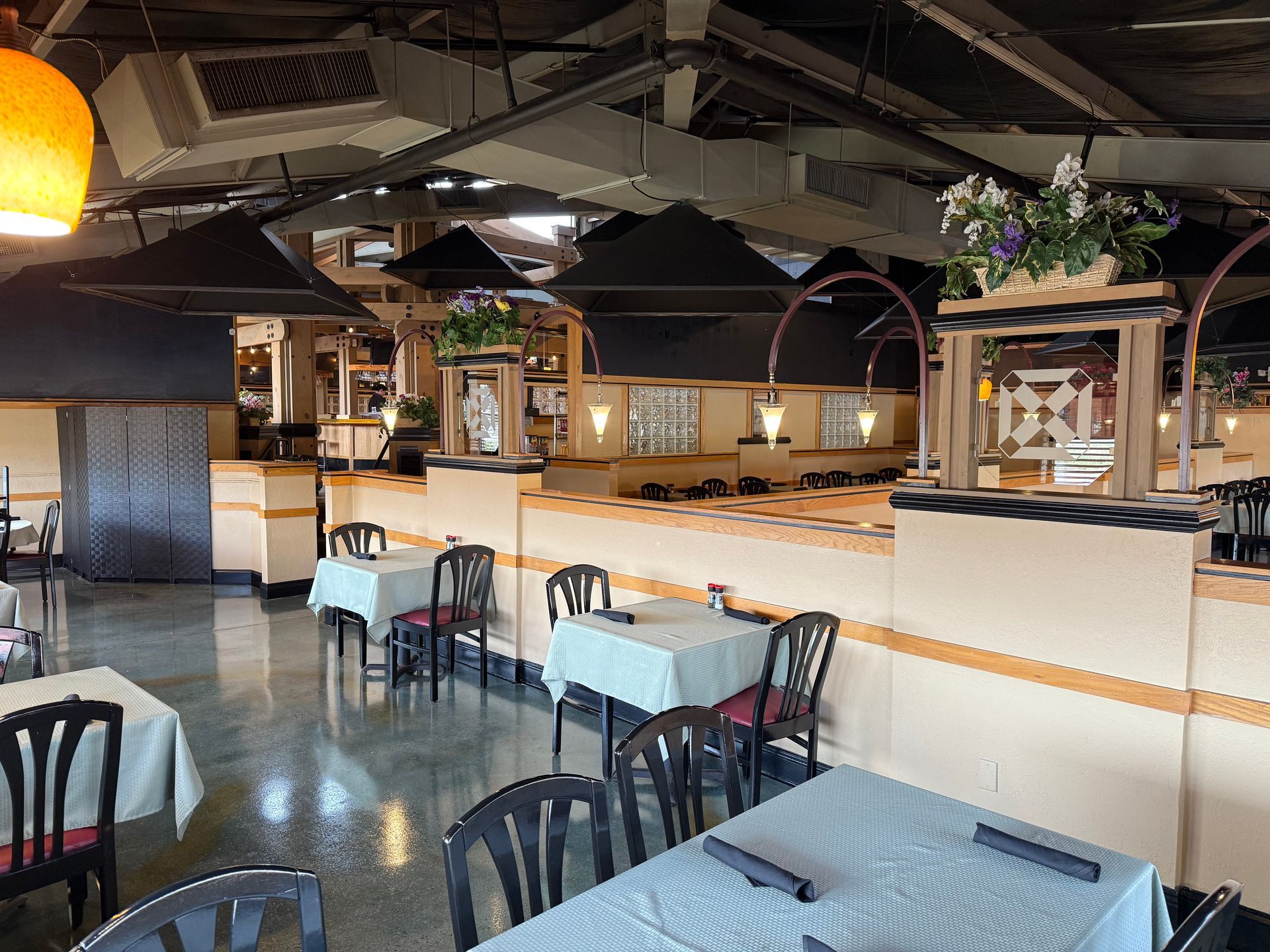 A restaurant with tables and chairs and flowers on the ceiling