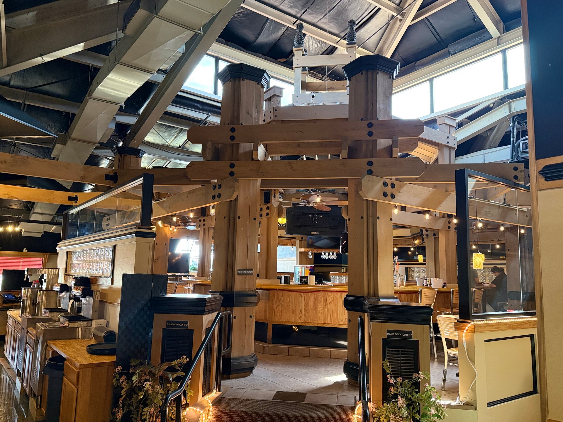A large wooden structure is in the middle of a restaurant.