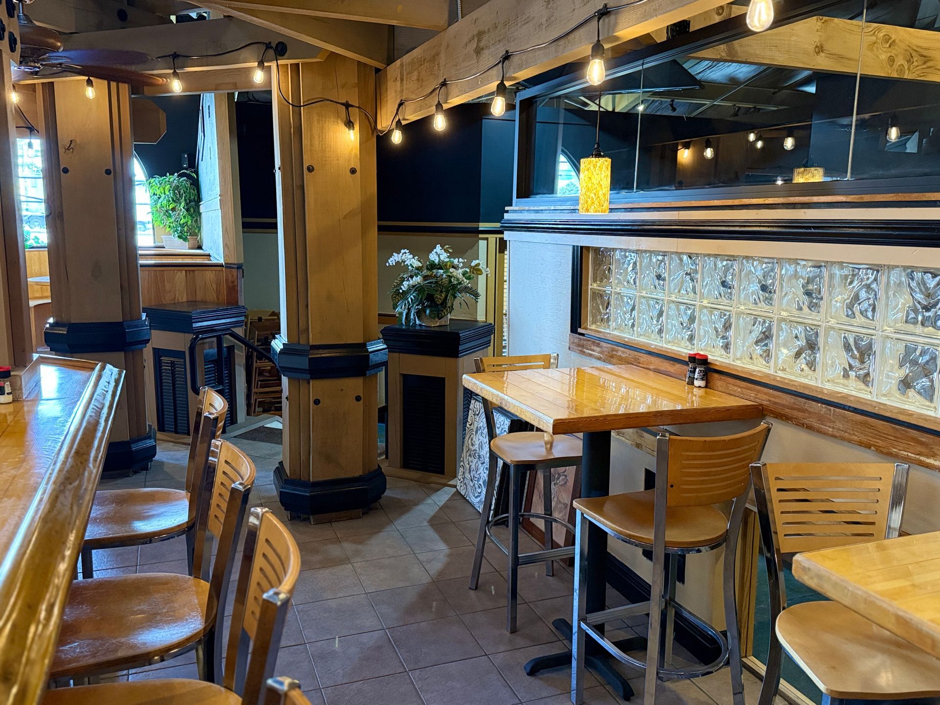 A restaurant with tables and chairs and a bar.