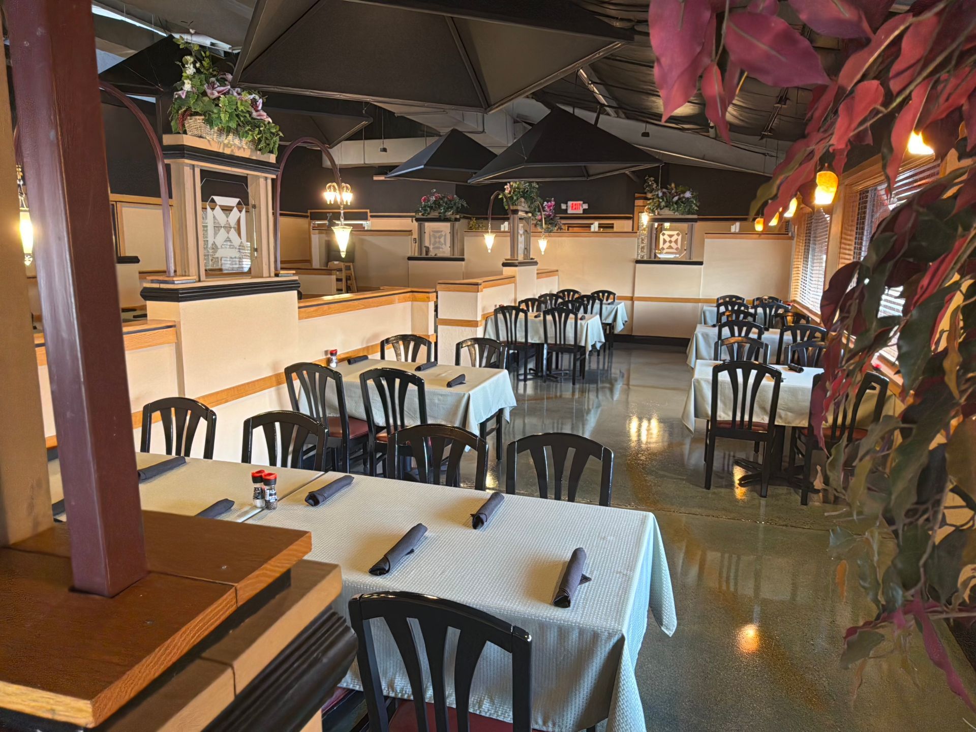 A restaurant with tables and chairs set up for dinner
