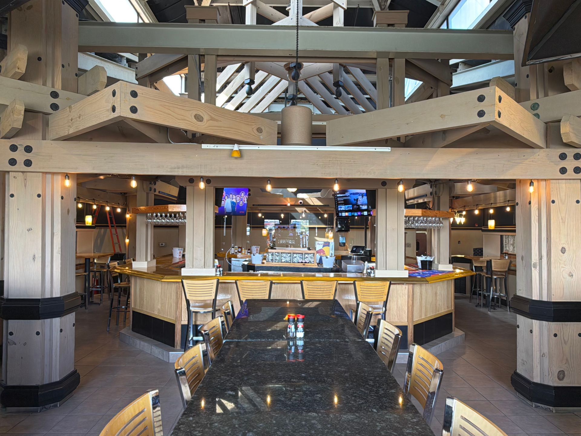 A restaurant with a long table and chairs and a bar