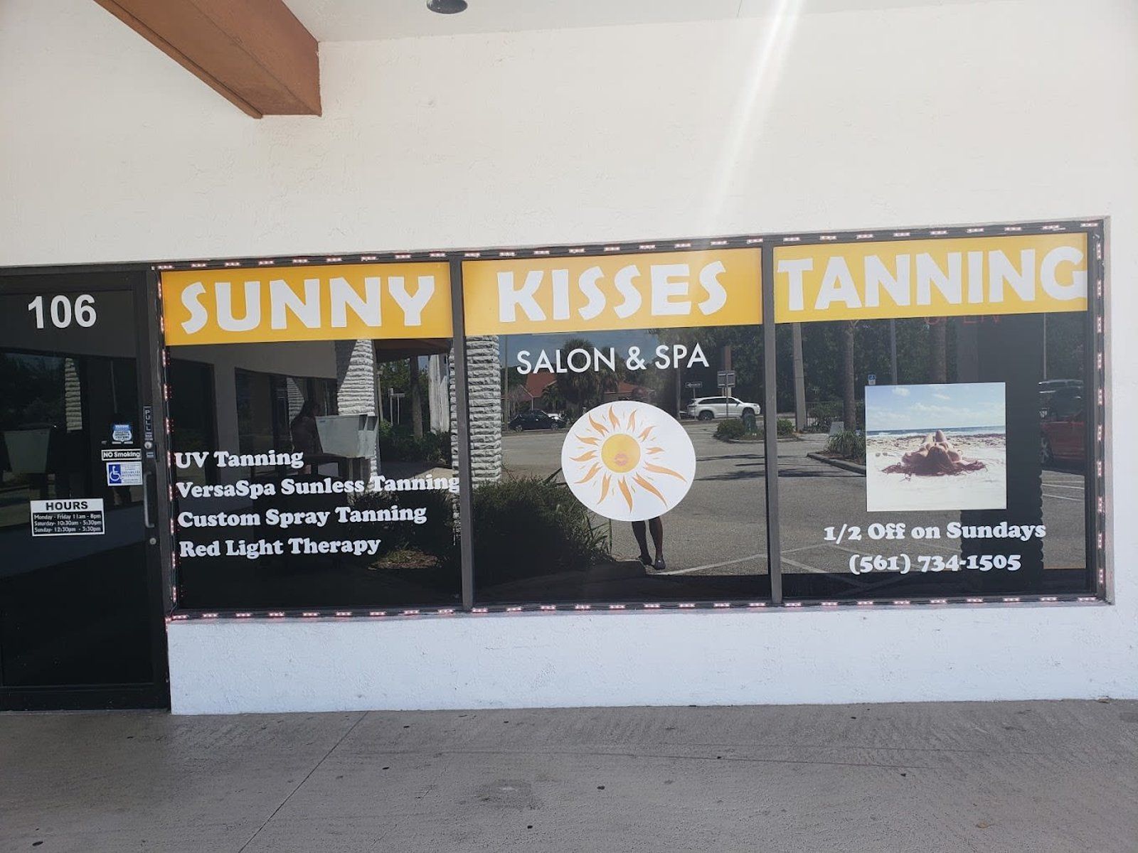 Sunny Kisses Tanning Salon & Spa storefront with yellow lettering on a black window.