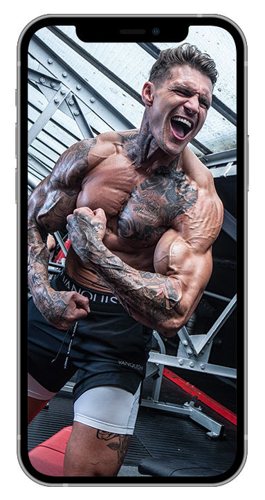 A man with tattoos is flexing his muscles in a gym on a cell phone.