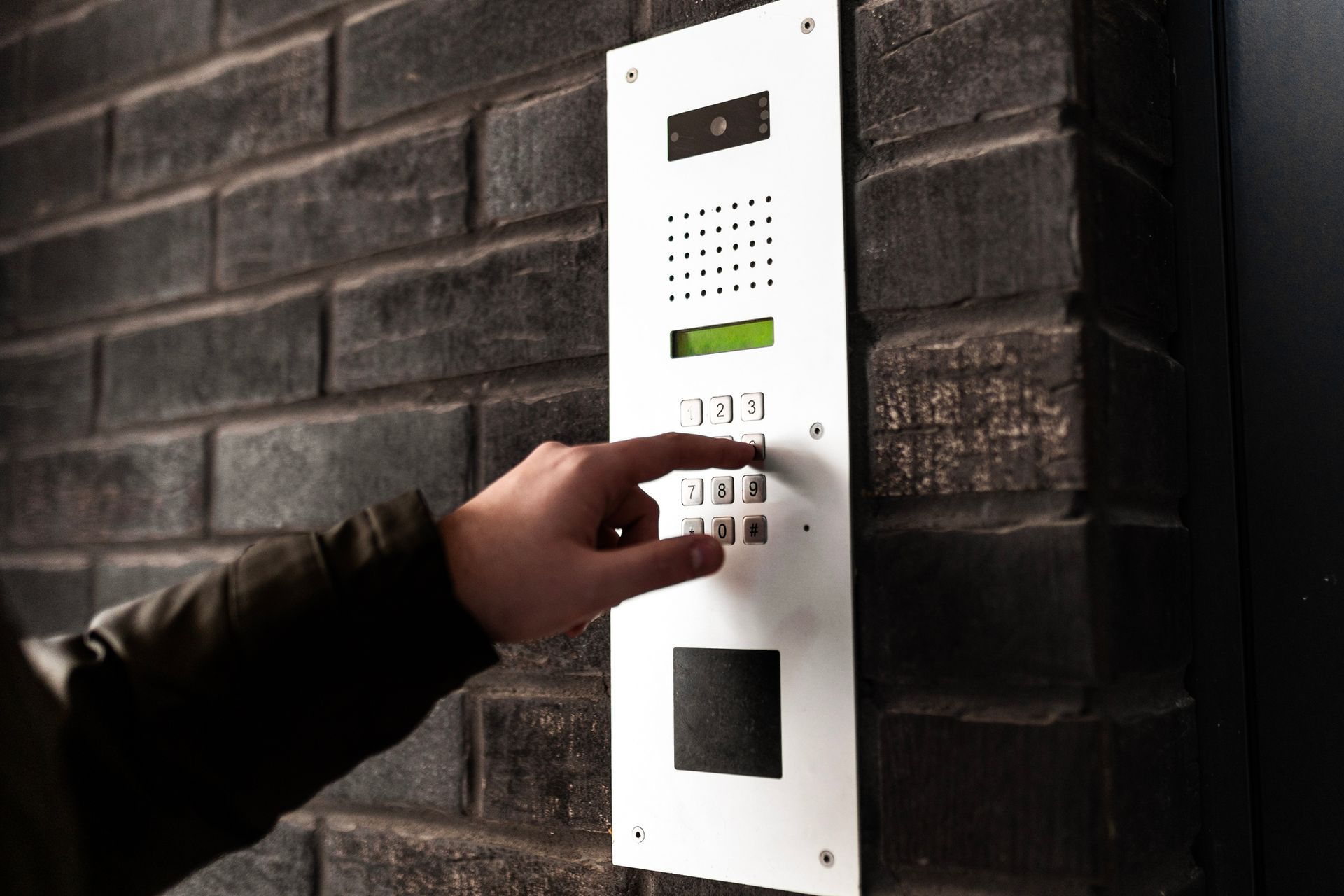 Individual activating an intercom, highlighting functionality in commercial access control systems.