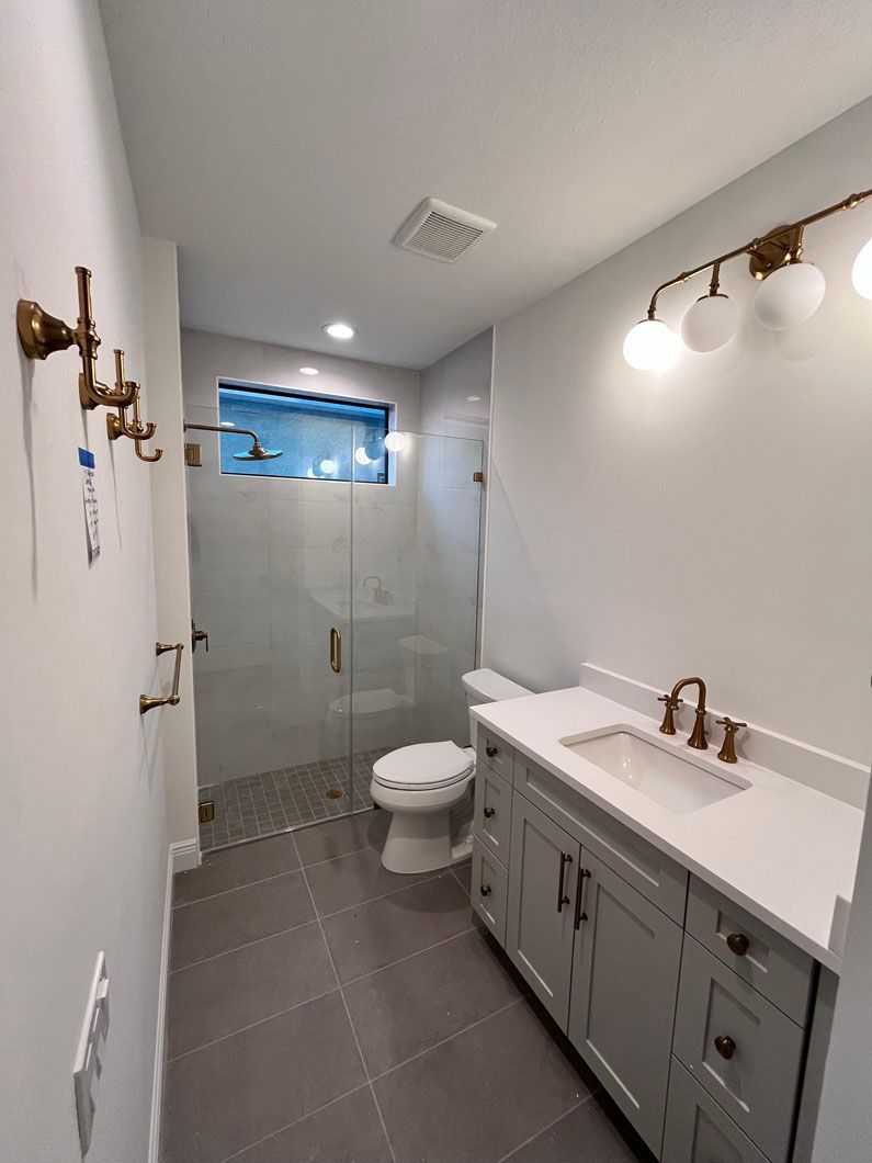 A bathroom with a toilet , sink , and shower.