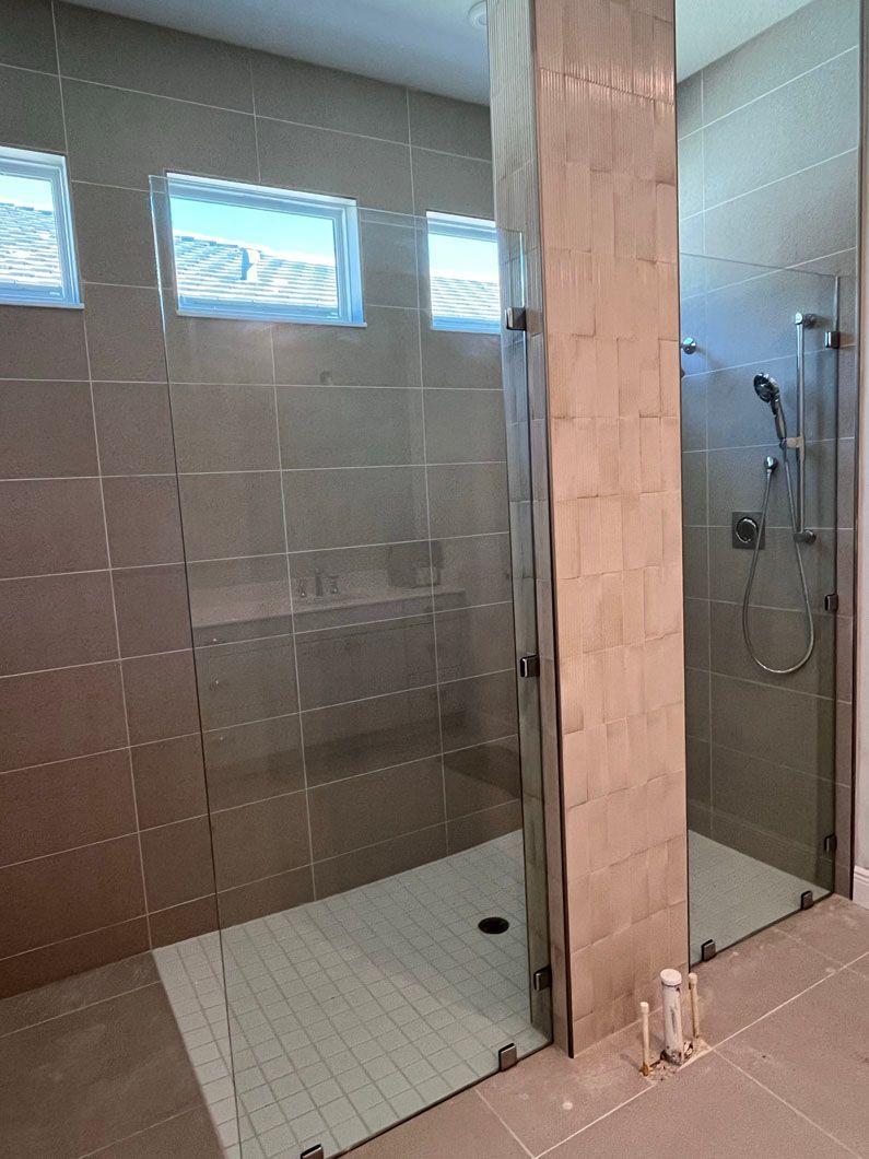 A bathroom with a walk in shower and a glass door.