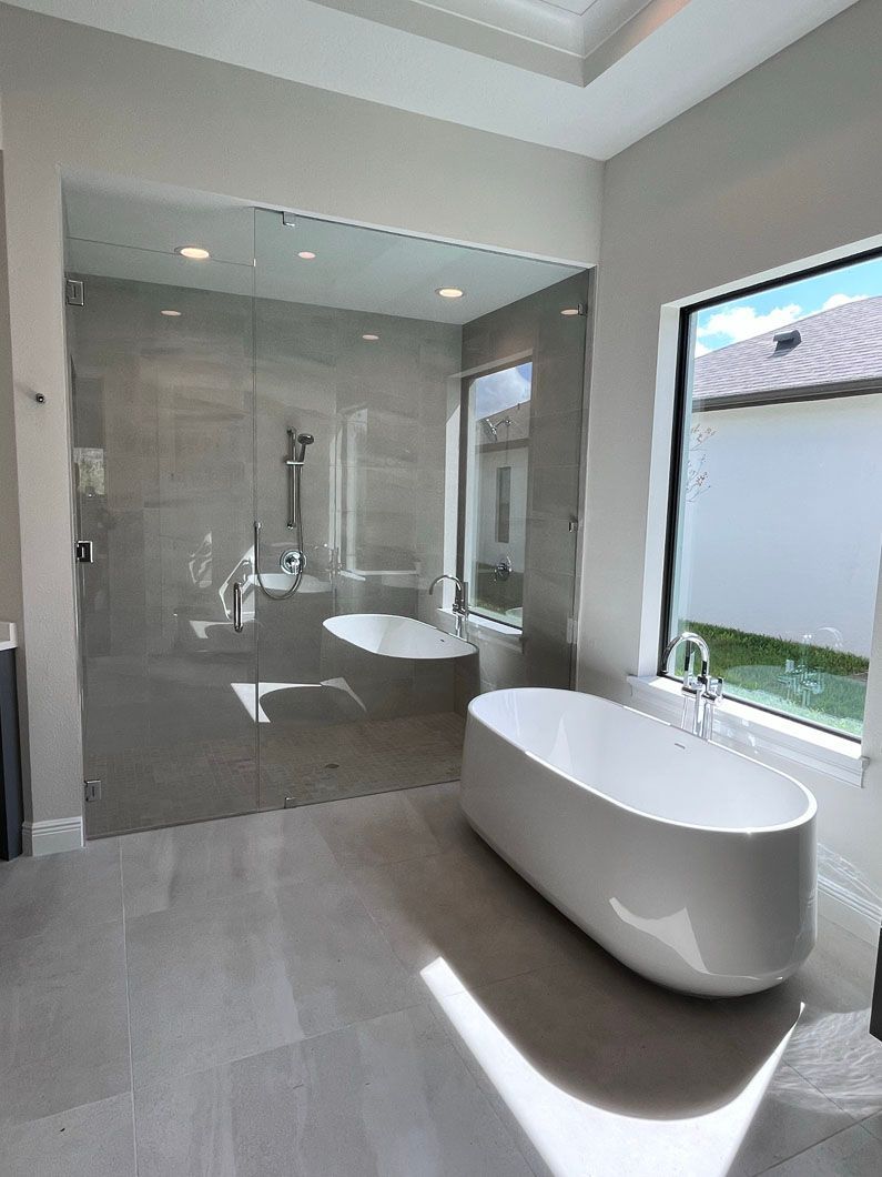 A bathroom with a tub , shower , and window.