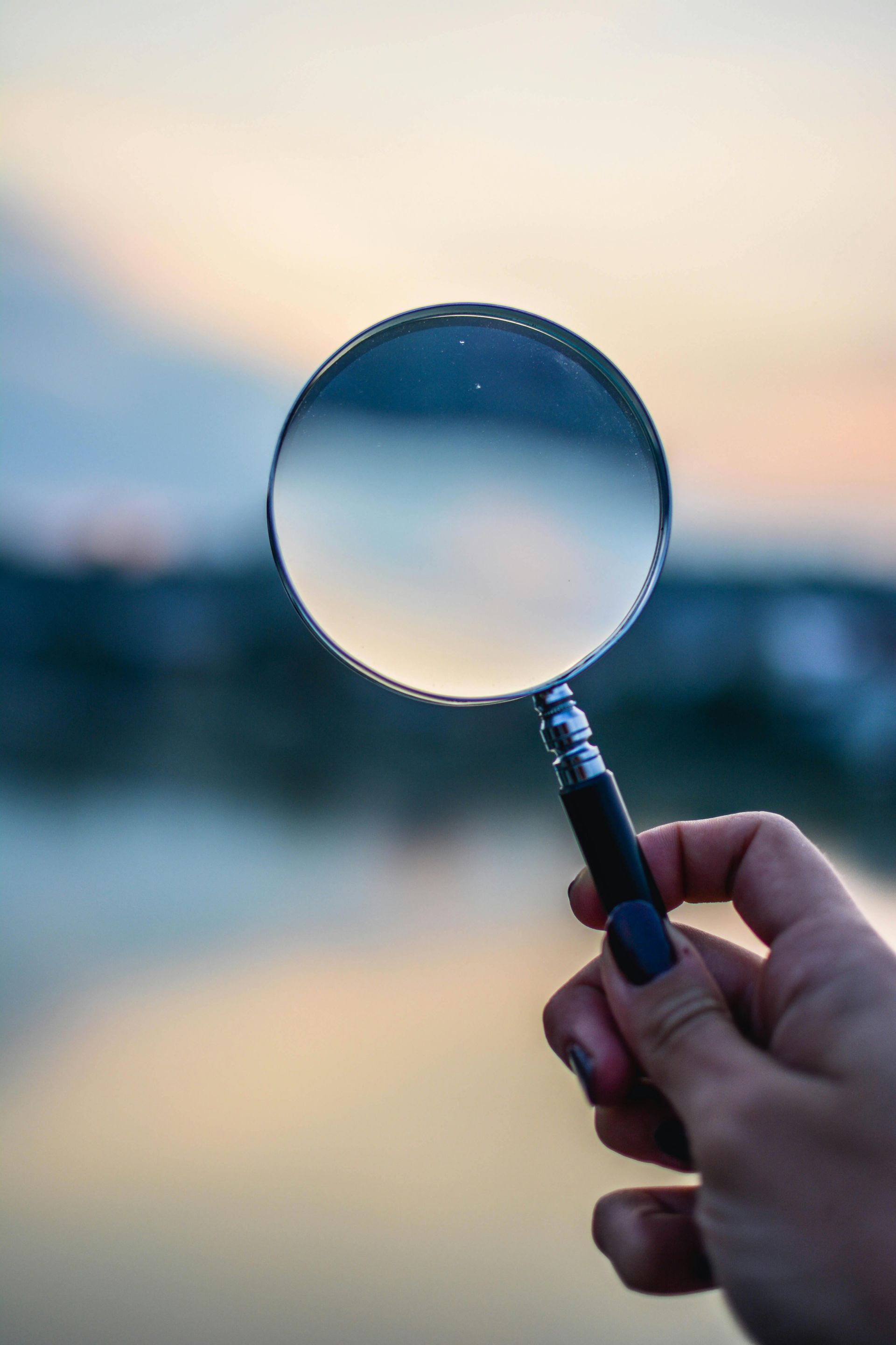 A person is holding a magnifying glass in their hand.