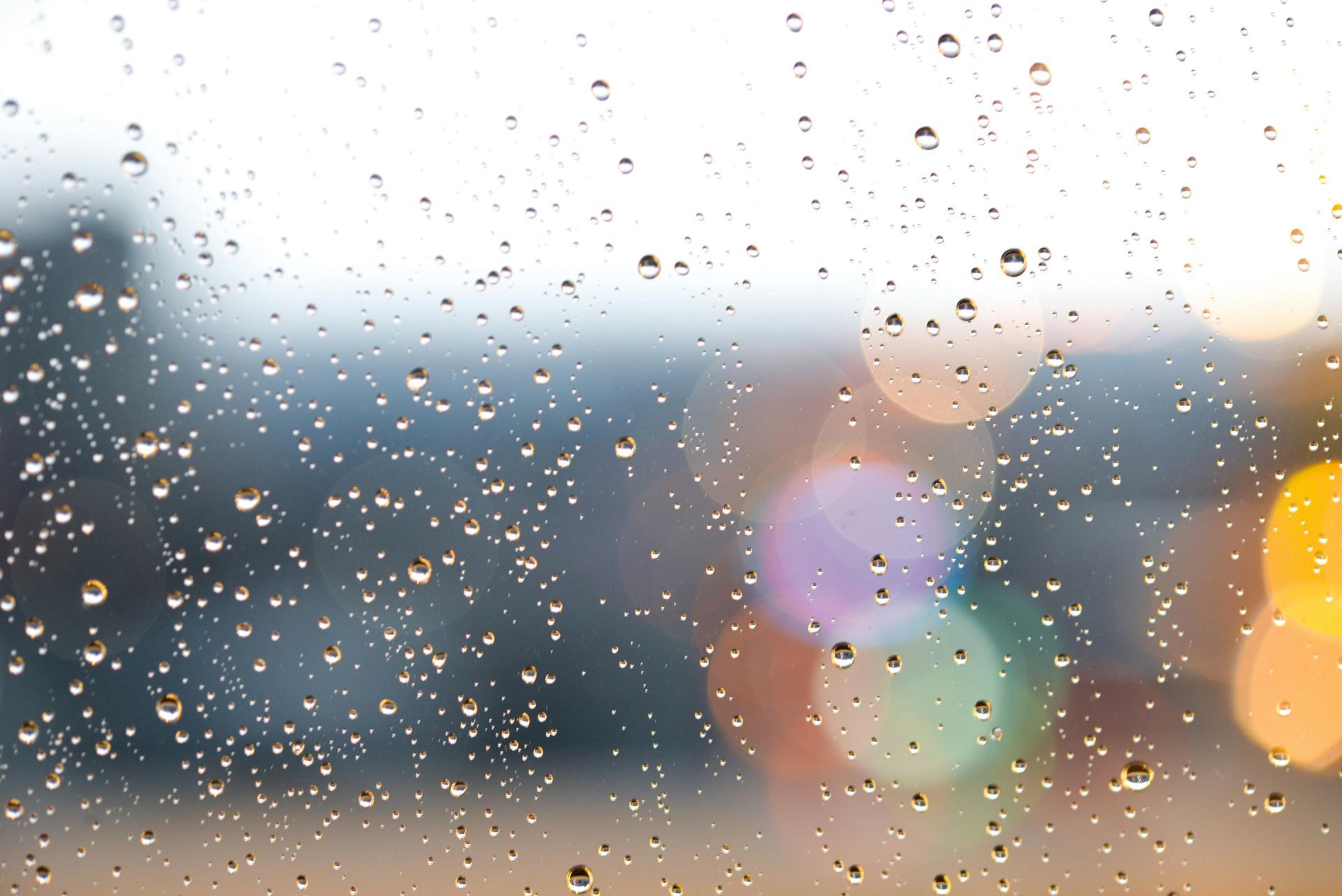 Rain drops on a window with a blurry background
