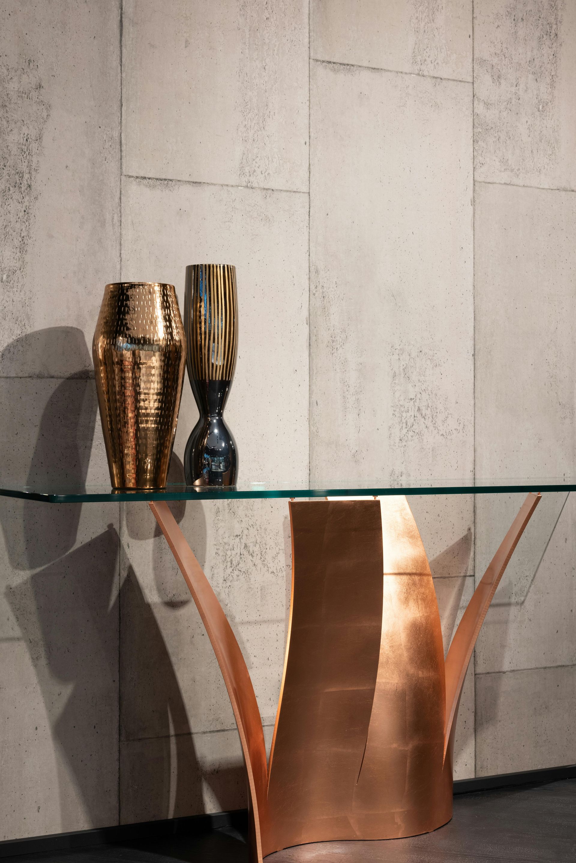 A glass table with two vases on top of it
