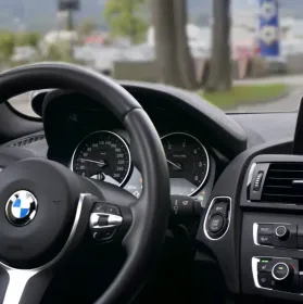 A picture of a cars dashboard with the driving wheel