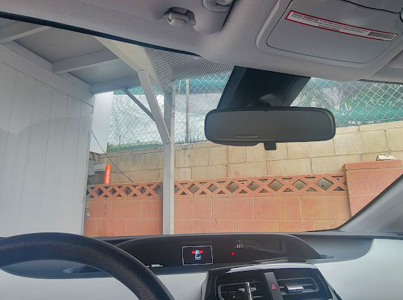 A picture of a windshield looking outside a garage with window tint film installed
