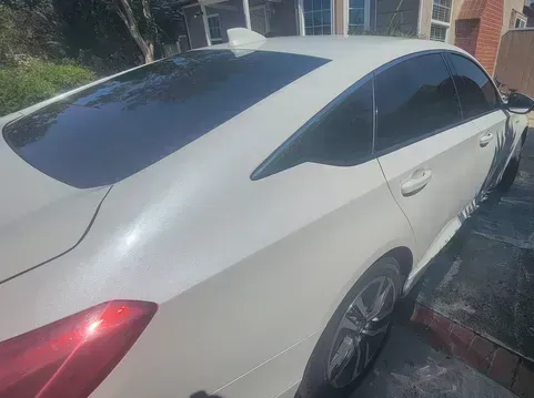 A picture of the backside of a white car with window tint installed