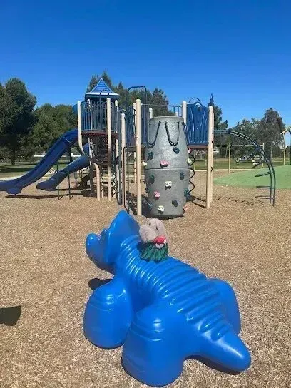 Window Tinting Service-A stuffed animal is sitting on top of a blue crocodile in a playground.