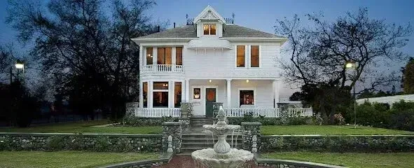 Window Tinting Service-A large white house with a fountain in front of it.