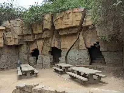 Window Tinting Service-A group of picnic tables in front of a rock wall