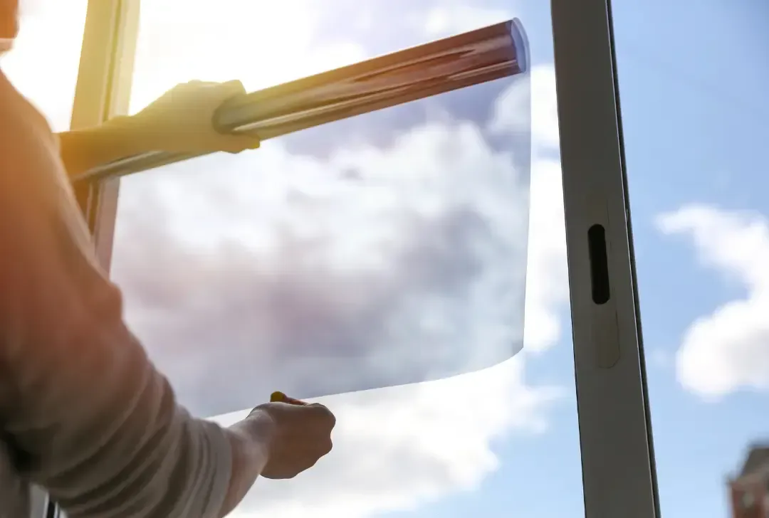 A person is cleaning a window with a squeegee.